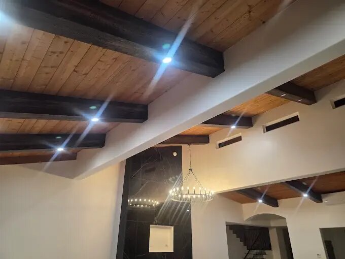 Recessed can lighting laid out in a wood-beam ceiling by All Current Electric